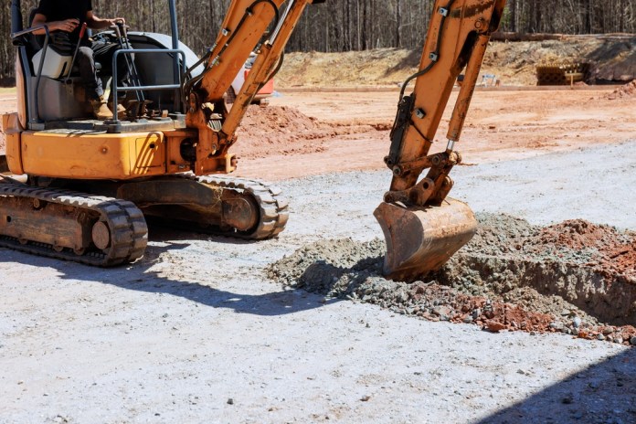 Worker,Operates,An,Excavator,To,Dig,Trench,At,Construction,Site Rezago en ejecución de obras sigue latente. Foto La Hora: Shutterstock
